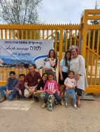 צילום פרידה על רקע שלט התודה ממשפחות קרית ששמונה